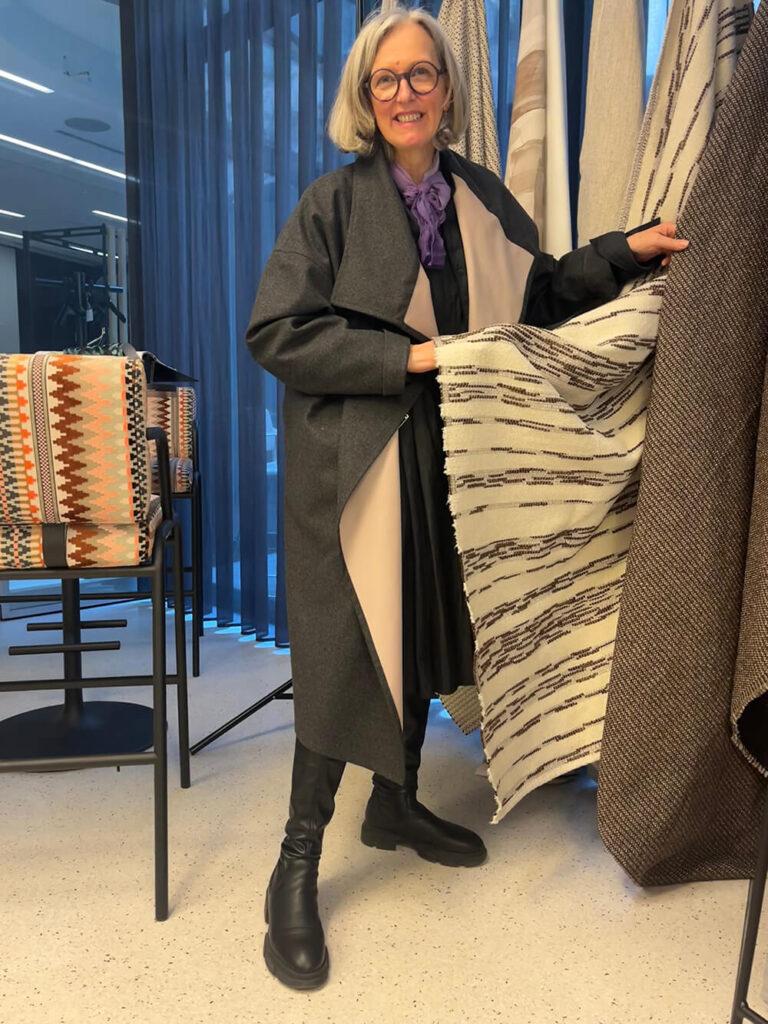 Schneiderin Katharina betrachtet Stoffmuster auf einer Interior-Design-Messe in Wien