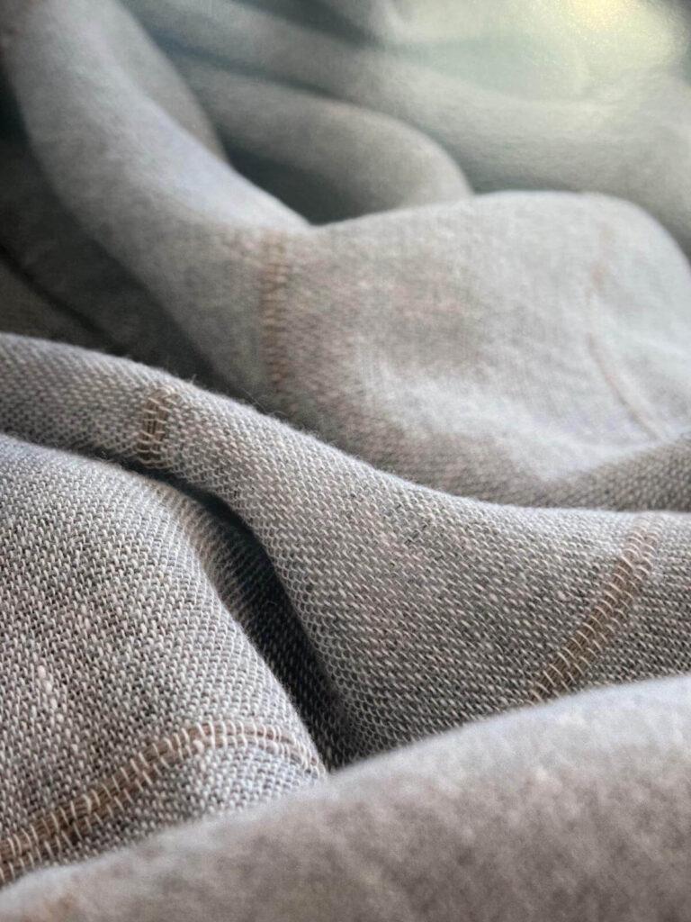 Detailaufnahme eines grob gewebten Stoffes mit sichtbarer Naht