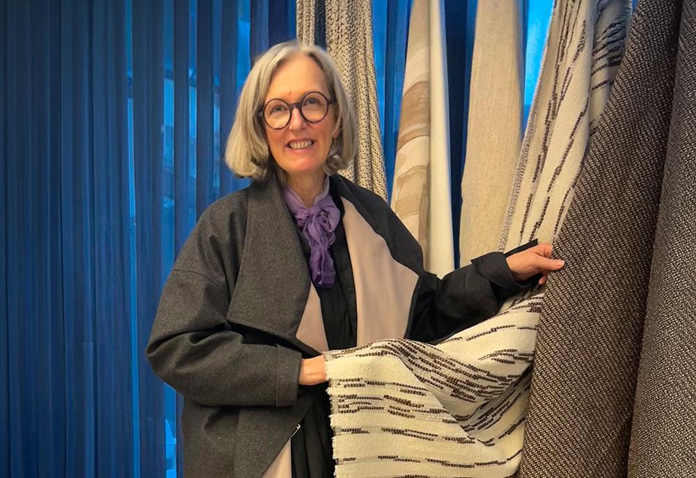 Schneiderin Katharina betrachtet Stoffmuster auf einer Interior-Design-Messe in Wien